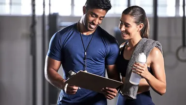 Instructor showing information to a female member at a gym